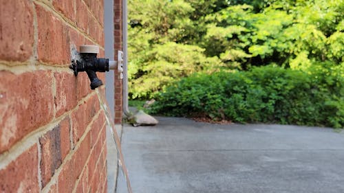 Water Running from Tap on Brick Wall