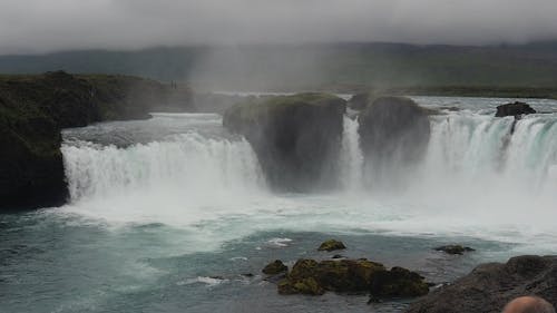 Man Having A Photo Taken Near A Waterfalls