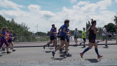 Tracking Shot of Marathon Runners Crossing a Bridge 