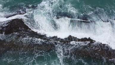 drone footage of waves in blue sea