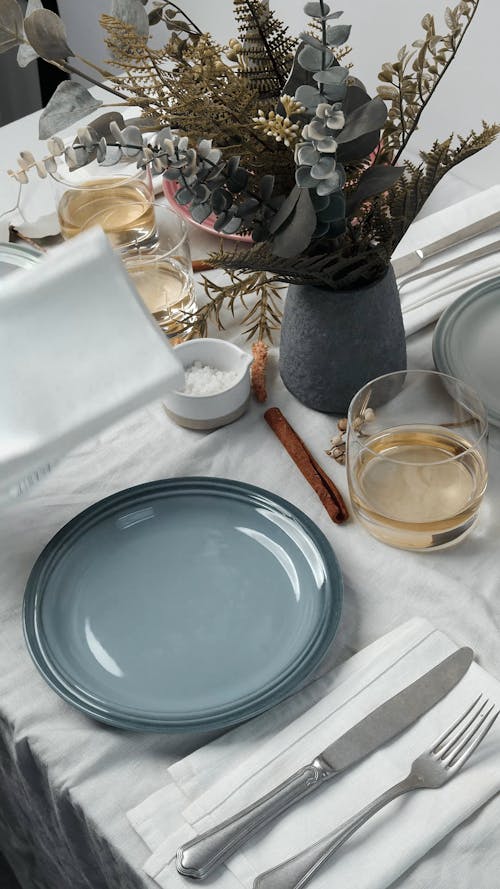 Hand Putting Cutlery and a Napkin on a Table