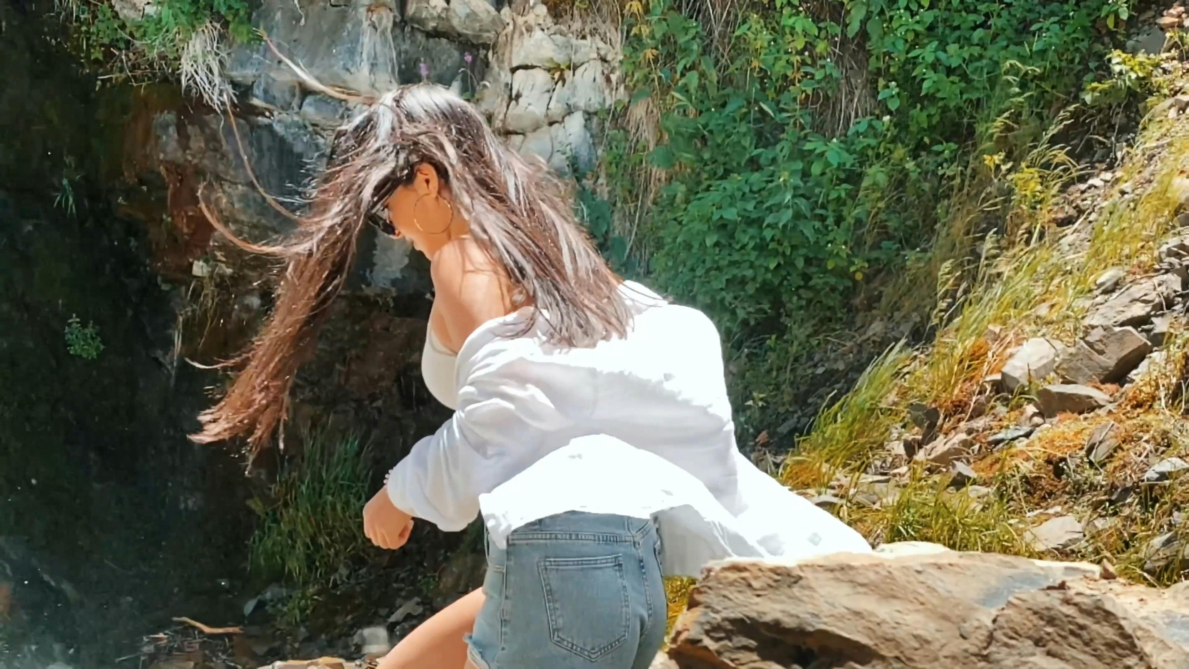 a young woman walking near a waterfall 12557295
