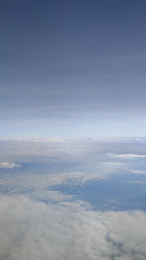 View from Airplane Flying Above Clouds