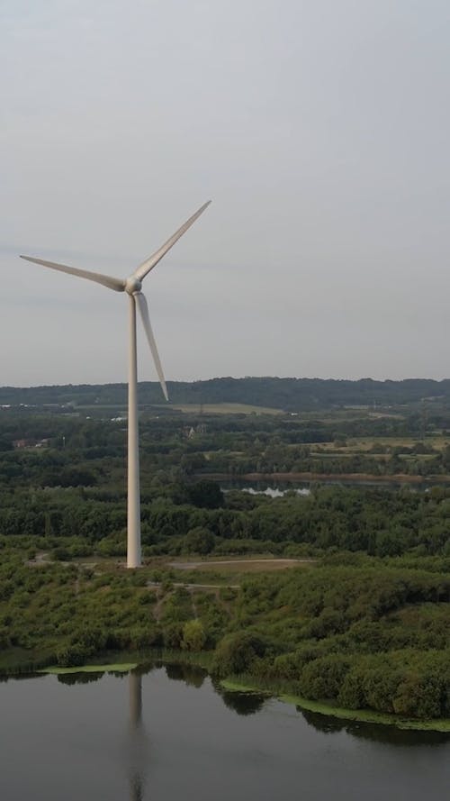 Drone Shot of a Wind Turbine Reflecting in a Lake