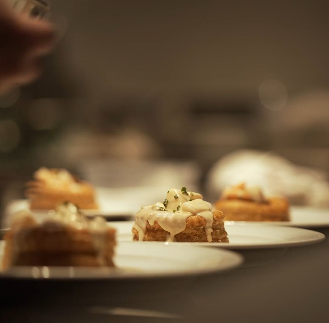 A row of plated desserts under low, warm light