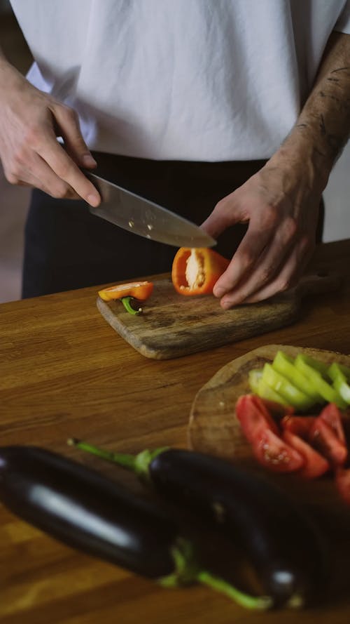 A Chef Cutting an Orange Bell Pepper 