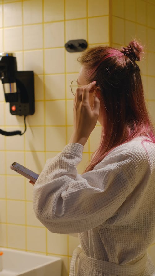A Young Woman in a Bathrobe Making a Phone Call 