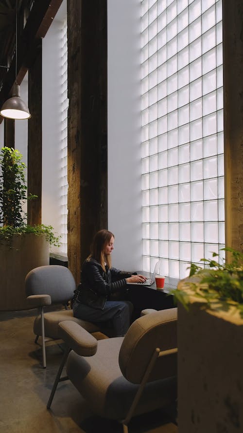 A Woman Using a Laptop and Drinking Coffee