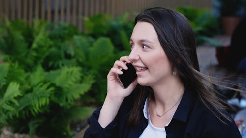 A Smiling Young Woman Taking on the Phone 