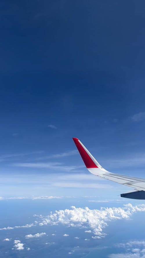 Window View from an Airplane Flying above the Clouds 