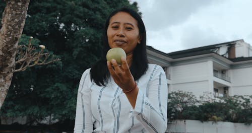 Woman Holding an Apple and Talking