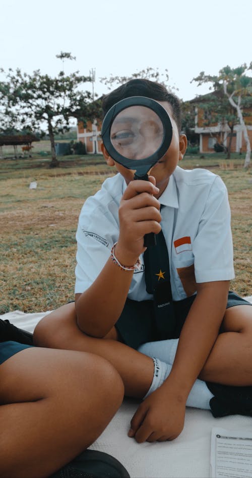 Schoolboys Having Fun Playing with a Magnifying Glass at a Field Trip