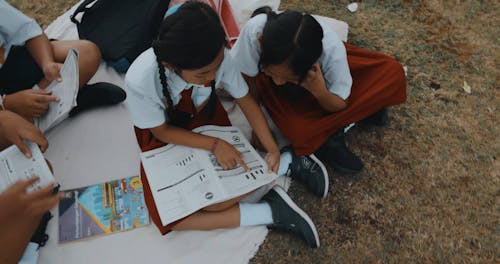 Students Reading Book on Picnic