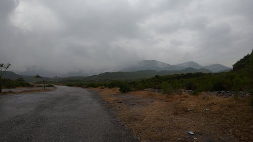 Time Lapse of Clouds Moving over a Road in a Mountain Landscape