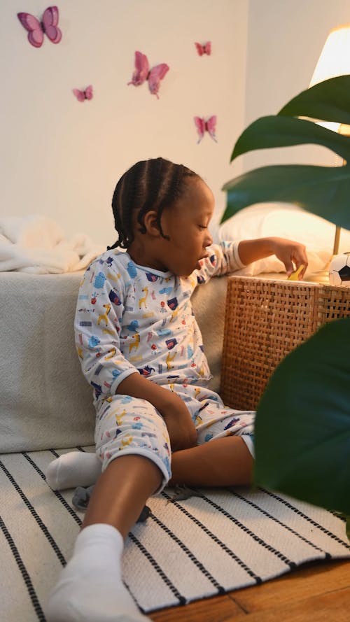 Boy in Pyjamas Playing with Toys in his Bedroom