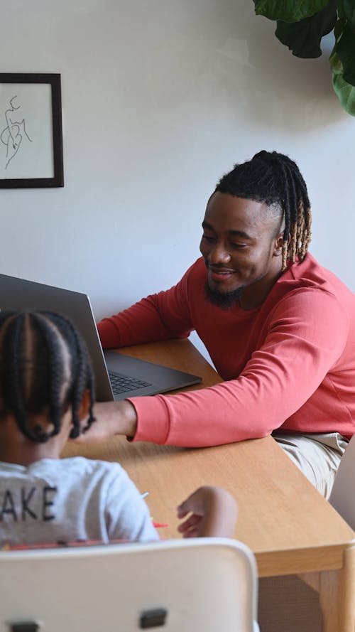 Father Using a Laptop and Playing with his Son