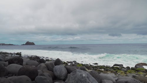 Breaking Waves on a Rocky Beach under a Grey Sky 