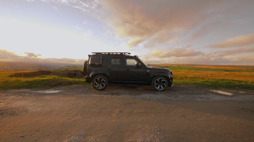 A Black Land Rover Defender Parked in a Field 