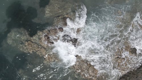 Top View of Waves Breaking on Rock Formations 