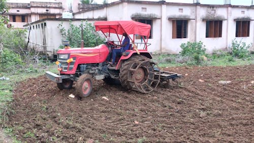 Farmer in a Tractor Plowing a Field
