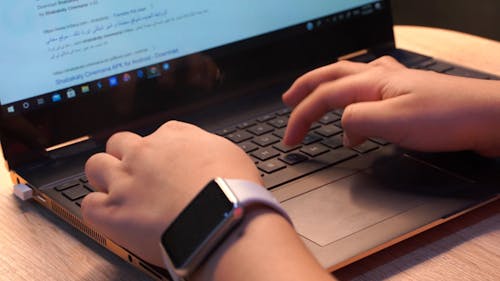 Hands of a Person Typing on a Laptop Keyboard