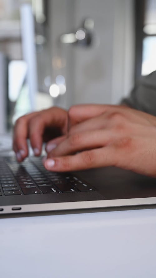 Close-up of Hands of a Person Typing on a Laptop