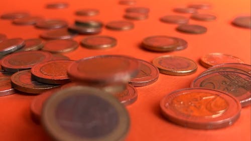 Euro Coins Falling on an Orange Surface