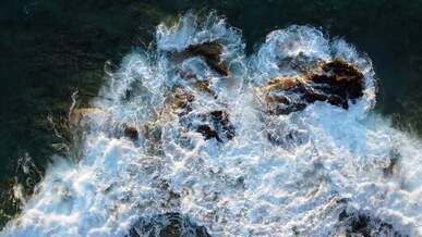 top view of breaking waves on rock formations