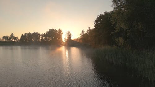 Drone Video of a Lake in a Rural Area at Sunrise 