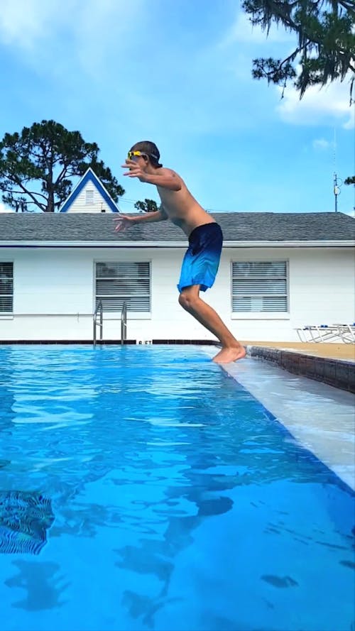 A Teenager Jumping into a Swimming Pool