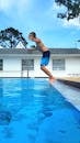 A Teenager Jumping into a Swimming Pool