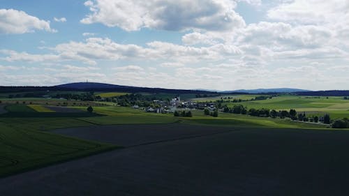 Drone Video of Green Fields and a Small Village in a Rural Area 