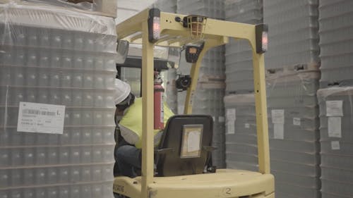 Man Driving Forklift in Warehouse