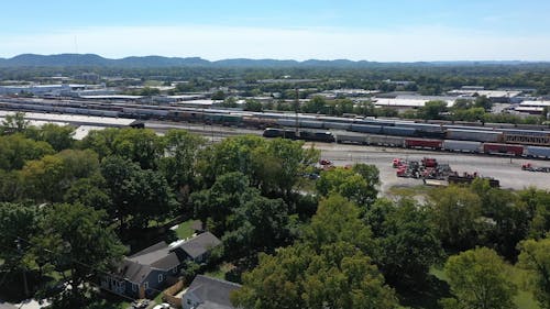 Drone Footage of a Cargo Train Passing by a Rail Yard