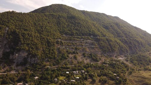 Drone Footage of a Winding Road on a Green Mountain 