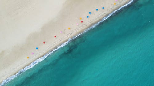 Top View of a Sandy Beach with Colorful Parasols