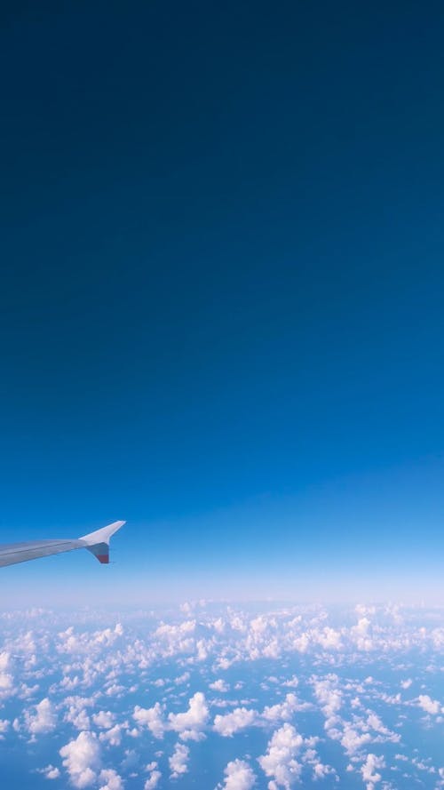 View from a Plane Window while Flying above the Clouds 