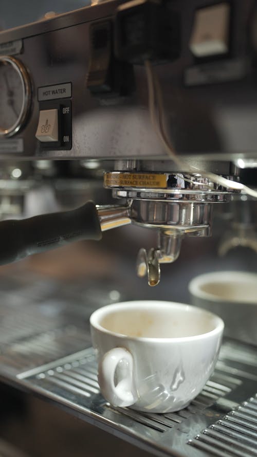Close up of an Espresso Machine and a Ceramic Cup