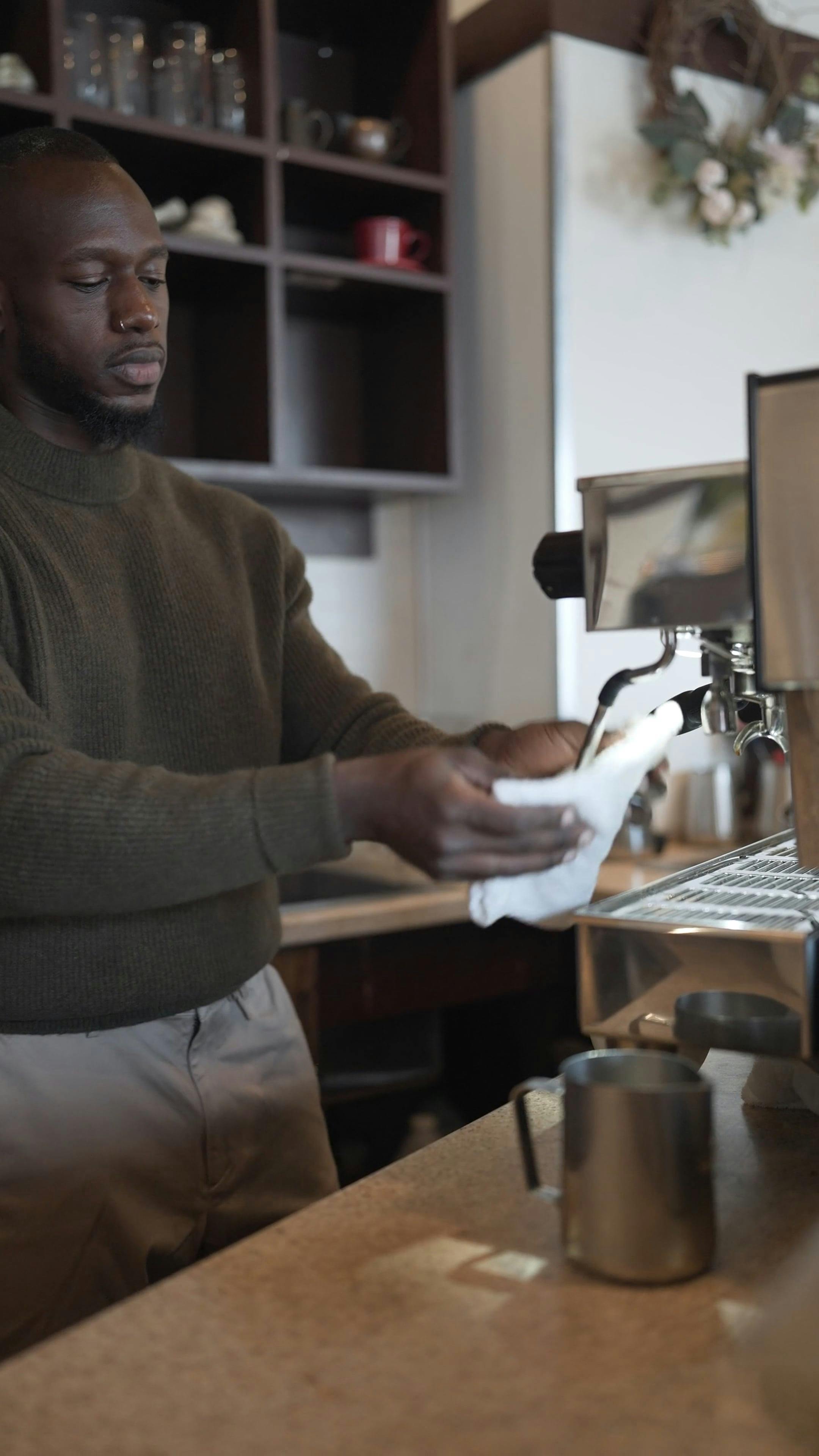 A Barista Cleaning the Steam Wand on an Espresso Machine Free Stock