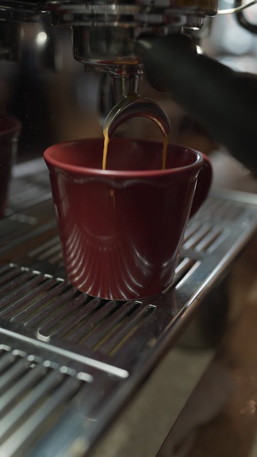 Close up of an Espresso Machine Filling a Ceramic Cup 