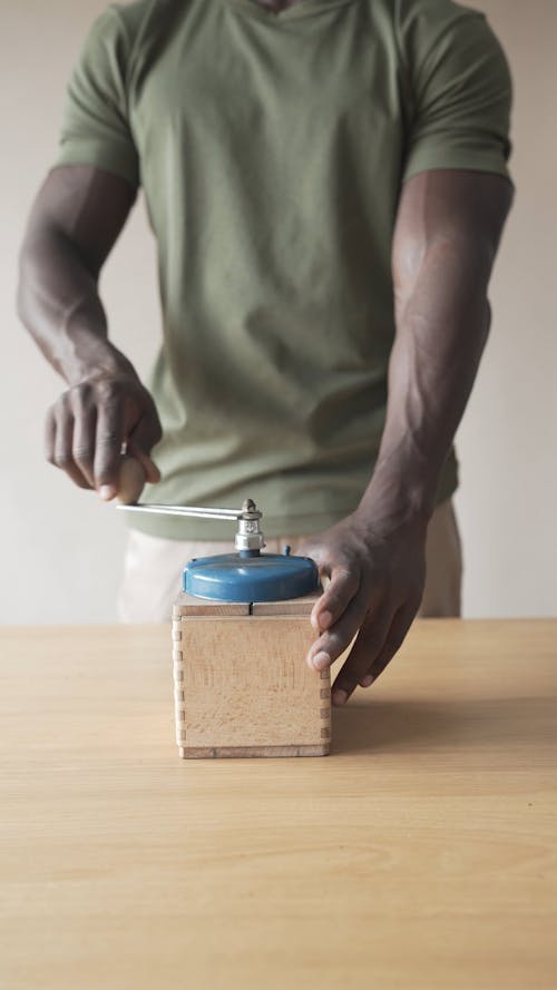 A Person Using a Traditional Manual Coffee Grinder 