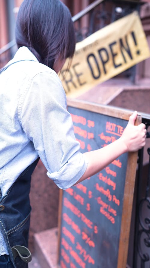 Person Putting the Menu Board Outside