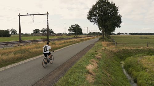 Man Cycling on Empty Road