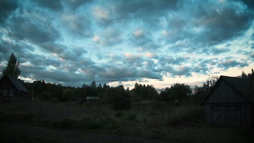 Time Lapse of Moving Clouds over a Small Village at Sunset 