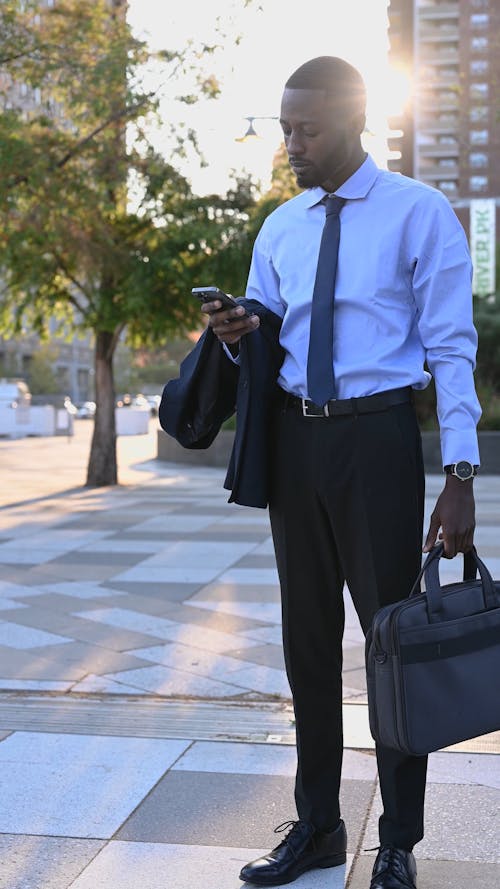 Man Standing on the Street Using His Mobile Phone