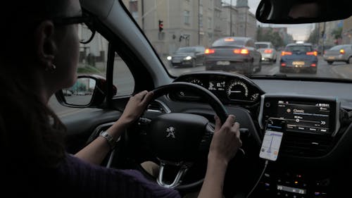 A Woman Wearing Eyeglasses Driving a Vehicle