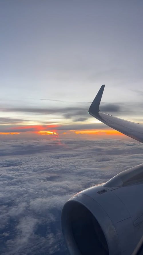 Window View from an Airplane Flying above the Clouds 