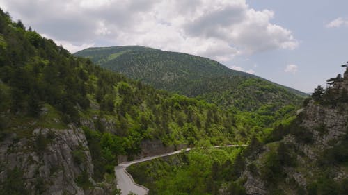 Aerial Footage of Road Between Hills and Mountains