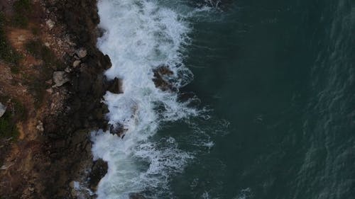 Sea Waves Crashing Against Rocks in Overhead View
