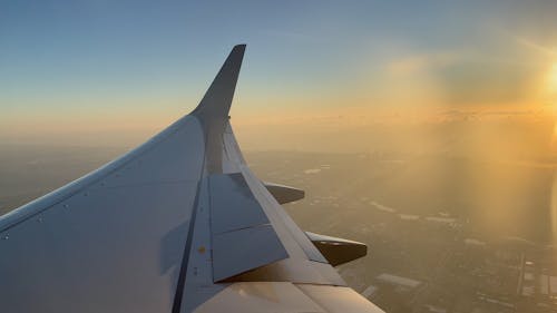 Airplane Window View while Flying over a City at Sunset